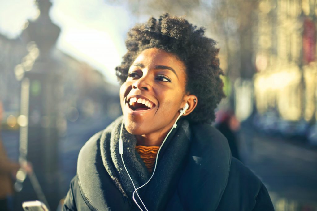 Photo of a woman smiling and listening to music 
